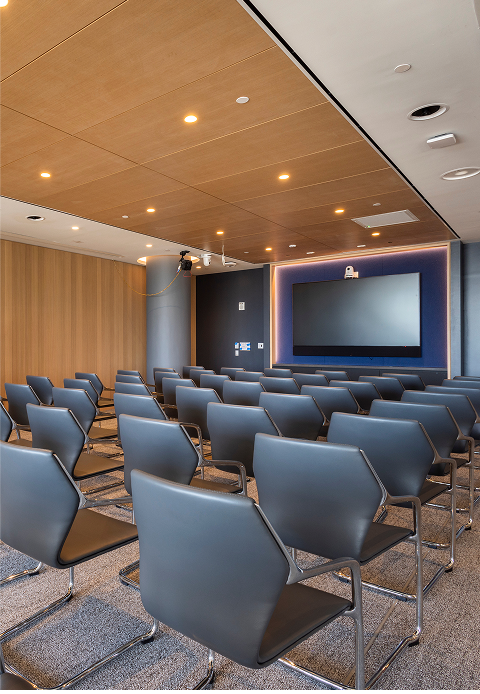 Conference room with theater-style seating, wood-paneled walls, and screen setup at level10.