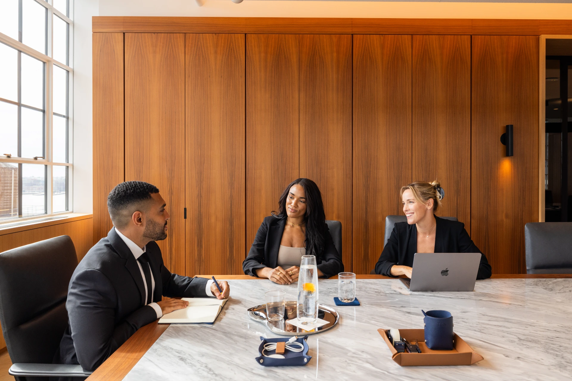 Executive meeting in a modern conference room at level ten nyc with marble boardroom table wood paneled walls and business professionals collaborating
