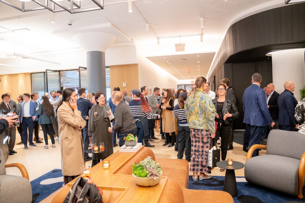 Guests mingling and networking during a lively indoor cocktail reception in a modern event venue, featuring contemporary