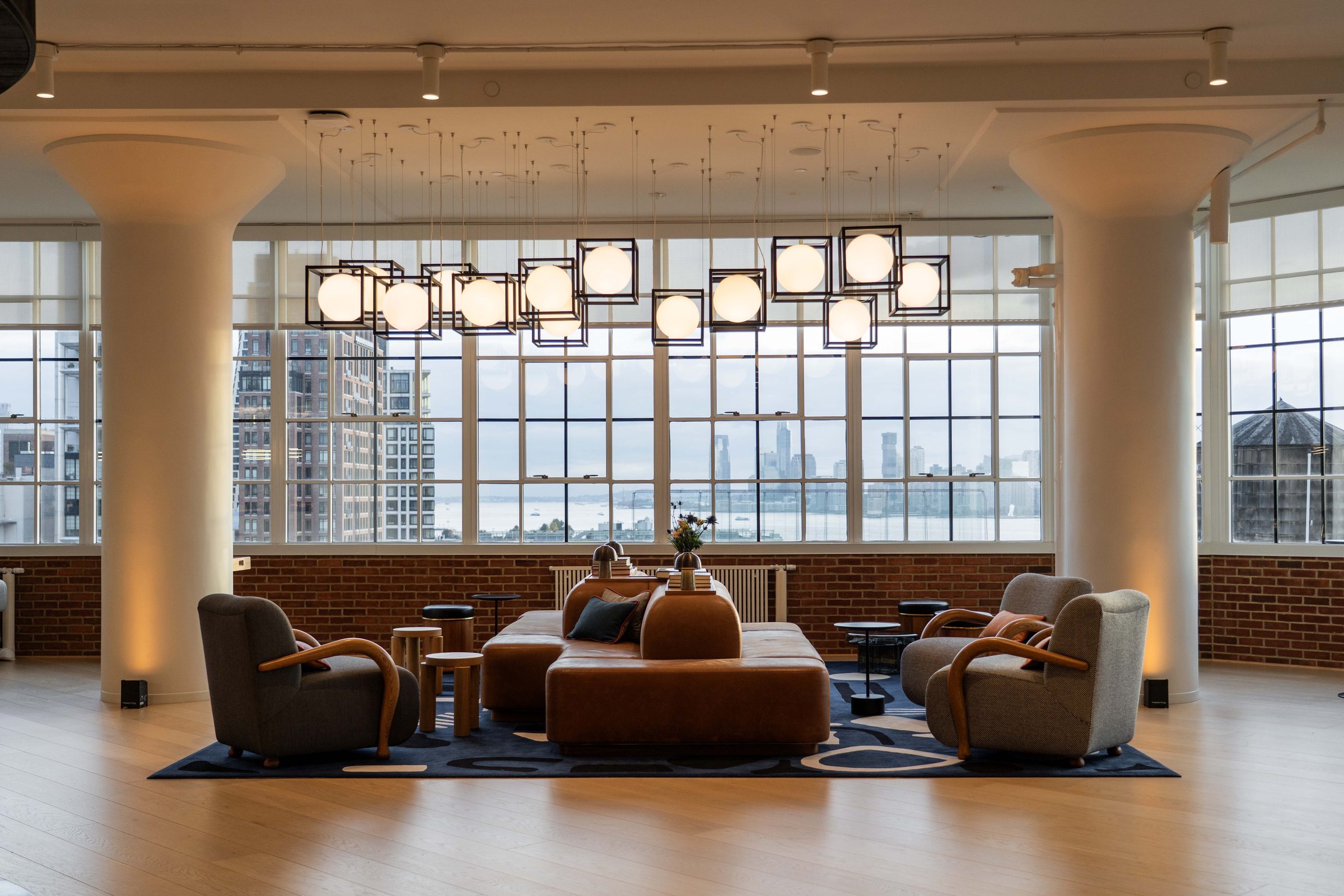 Executive boardroom at level10 with a long white marble conference table, black leather chairs, embedded led lighting strips, fresh floral centerpieces in yellow, peach, and blue tones, and warm wood wall paneling